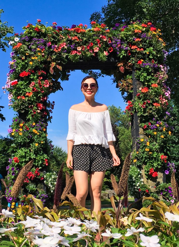 Montreal Botanical Garden floral arch Urban Planet off-the-shoulder top Forever 21 shorts sunglasses Asos sandals leather backpack (1)